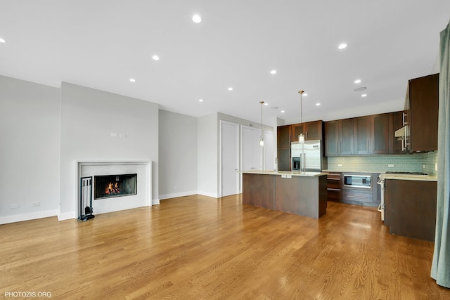 3321 N Sheffield Ave Unit 4, Chicago, IL 60657 - kitchen featuring built in appliances, light countertops, a kitchen island, open floor plan, and tasteful backsplash