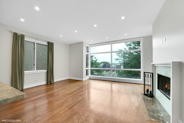 3321 N Sheffield Ave Unit 4, Chicago, IL 60657 - unfurnished living room with floor to ceiling windows, a warm lit fireplace, recessed lighting, and wood finished floors