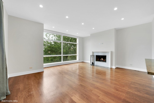 3321 N Sheffield Ave Unit 4, Chicago, IL 60657 - unfurnished living room with recessed lighting, a fireplace with flush hearth, wood finished floors, and a wall of windows