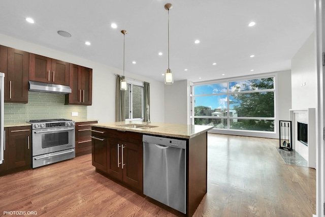 3321 N Sheffield Ave Unit 4, Chicago, IL 60657 - kitchen with appliances with stainless steel finishes, under cabinet range hood, tasteful backsplash, light wood-type flooring, and expansive windows