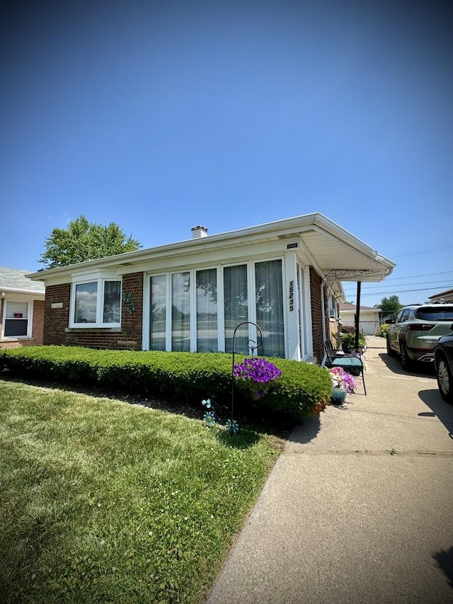 15235 Cottage Grove Ave, Dolton, IL 60419 - view of front facade featuring brick siding, a front yard, and a chimney