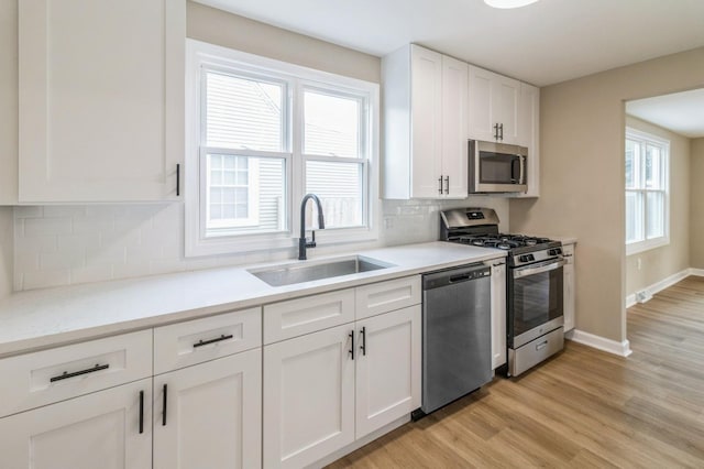 9934 Herrick Ave, Franklin Park, IL 60131 - kitchen featuring stainless steel appliances, white cabinets, light wood finished floors, tasteful backsplash, and light countertops