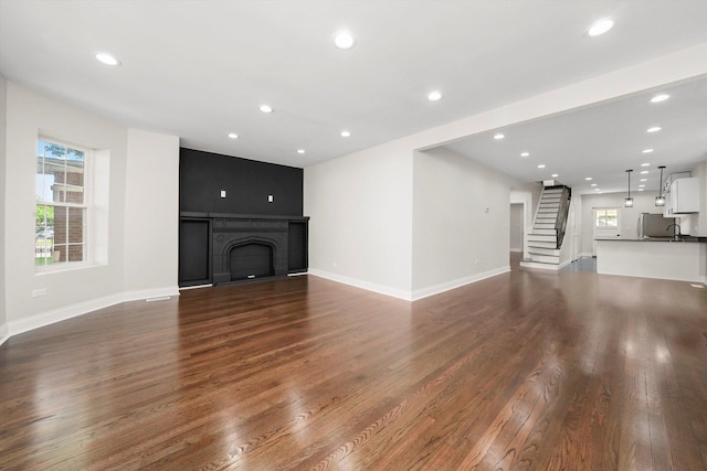 7711 S Honore St, Chicago, IL 60620 - unfurnished living room with dark wood-type flooring, recessed lighting, stairs, and a fireplace