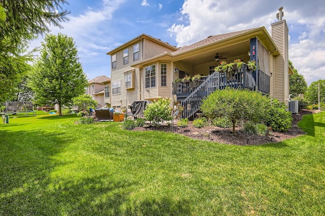 12723 Hawks Bill Ln, Plainfield, IL 60585 - rear view of house featuring ceiling fan, a trampoline, a lawn, stairs, and a chimney