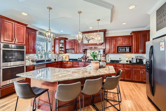 12723 Hawks Bill Ln, Plainfield, IL 60585 - kitchen with stainless steel appliances, reddish brown cabinets, crown molding, a kitchen island, and a chandelier