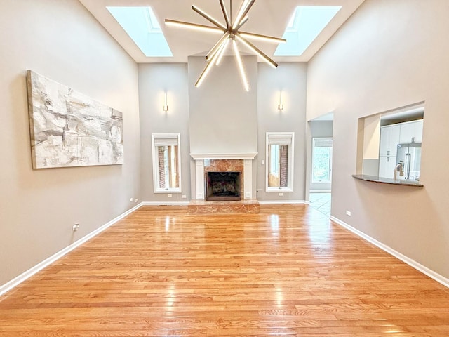 26159 N Hill Ave, Wauconda, IL 60084 - unfurnished living room featuring a skylight, a high ceiling, light wood-style flooring, and a fireplace