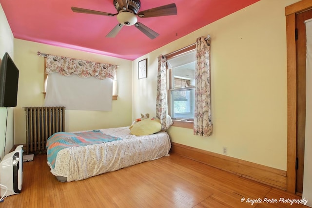 1100 N Hart St, Harvard, IL 60033 - bedroom featuring radiator, hardwood / wood-style flooring, and a ceiling fan