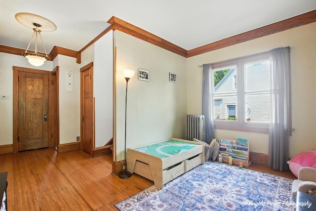 1100 N Hart St, Harvard, IL 60033 - bedroom with radiator heating unit, wood finished floors, and crown molding
