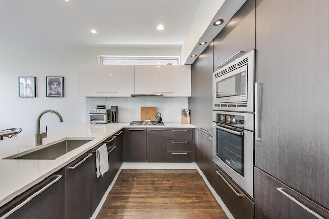 1028 N Hermitage Ave Unit 3, Chicago, IL 60622 - kitchen featuring appliances with stainless steel finishes, dark wood-style floors, light countertops, modern cabinets, and recessed lighting
