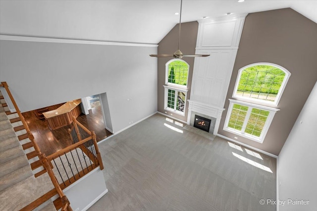 2814 Hapner Way, Batavia, IL 60510 - living room with a fireplace, high vaulted ceiling, stairs, ceiling fan, and carpet