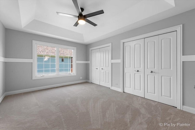 2814 Hapner Way, Batavia, IL 60510 - unfurnished bedroom featuring multiple closets, a tray ceiling, carpet, and a ceiling fan