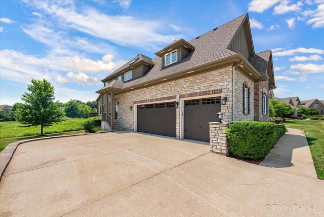 2814 Hapner Way, Batavia, IL 60510 - view of property exterior featuring stone siding, driveway, an attached garage, a shingled roof, and board and batten siding