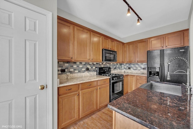1697 Deer Pointe Dr, South Elgin, IL 60177 - kitchen featuring black appliances, decorative backsplash, dark stone countertops, rail lighting, and light wood finished floors