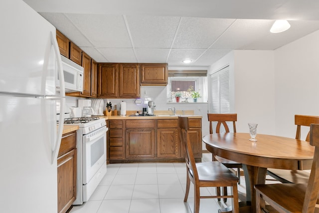 9429 S 55th Ave, Oak Lawn, IL 60453 - kitchen with white appliances, light countertops, brown cabinetry, a paneled ceiling, and light tile patterned floors