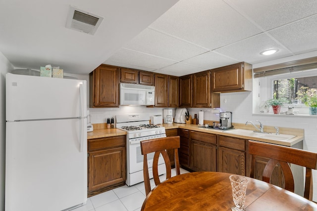 9429 S 55th Ave, Oak Lawn, IL 60453 - kitchen featuring white appliances, light countertops, tasteful backsplash, light tile patterned floors, and a paneled ceiling