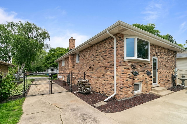 9429 S 55th Ave, Oak Lawn, IL 60453 - view of home's exterior with a gate, a chimney, brick siding, and driveway