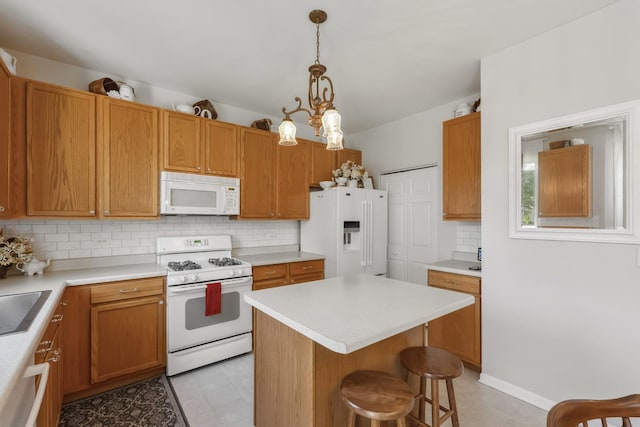 189 E Lark Ave, Cortland, IL 60112 - kitchen featuring white appliances, backsplash, a breakfast bar area, light countertops, and pendant lighting