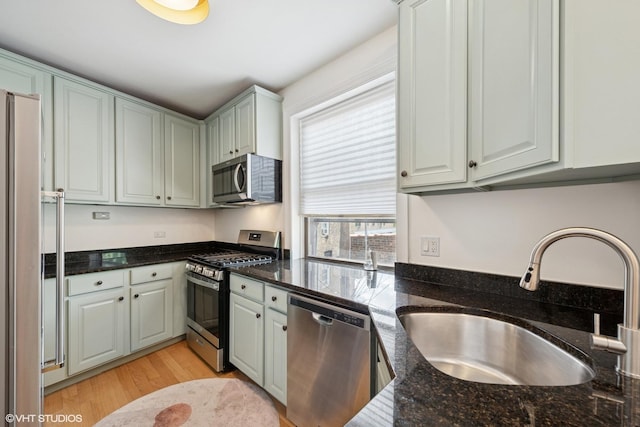 1219 W Lunt Ave Unit 1B, Chicago, IL 60626 - kitchen featuring appliances with stainless steel finishes, light wood-style flooring, and dark stone counters