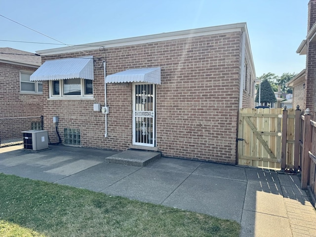 11137 S S Ave L, Chicago, IL 60617 - back of house featuring brick siding, a patio area, and a gate