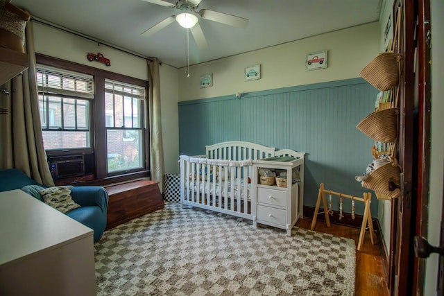 524 E 13th St, Lockport, IL 60441 - bedroom with a wainscoted wall, a crib, a ceiling fan, cooling unit, and wood finished floors