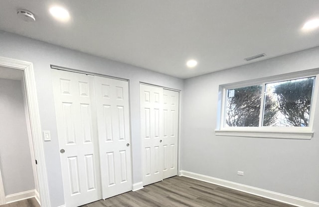 2100 Lloyd Ave, Lombard, IL 60148 - unfurnished bedroom featuring multiple closets, dark wood finished floors, and recessed lighting