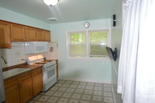 7921 Niles Ave, Skokie, IL 60077 - kitchen with white appliances, light flooring, backsplash, brown cabinetry, and dark countertops