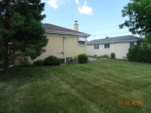 475 Courtesy Ln, Des Plaines, IL 60018 - back of house with a chimney, a yard, and brick siding