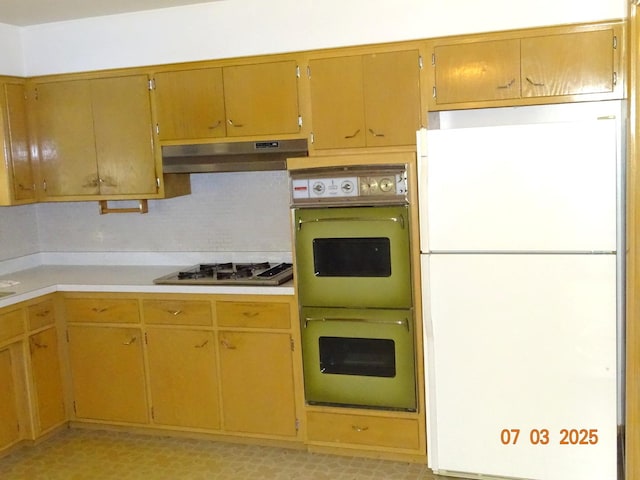 475 Courtesy Ln, Des Plaines, IL 60018 - kitchen with freestanding refrigerator, multiple ovens, stainless steel gas cooktop, under cabinet range hood, and light countertops