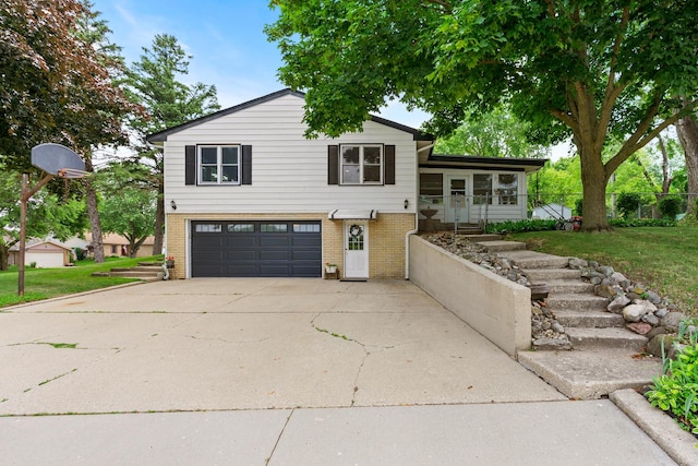 3717 W High St, Mchenry, IL 60050 - tri-level home with brick siding, a garage, a front lawn, and driveway