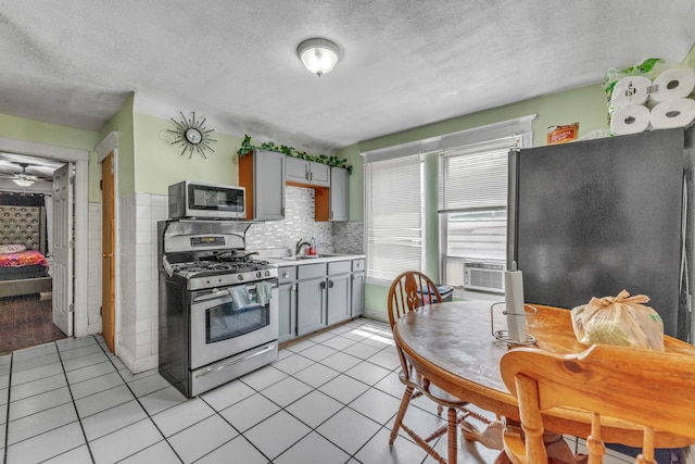 3031 S Central Park Ave, Chicago, IL 60623 - kitchen with appliances with stainless steel finishes, gray cabinetry, light tile patterned flooring, light countertops, and a textured ceiling