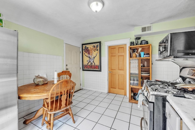 3031 S Central Park Ave, Chicago, IL 60623 - kitchen with appliances with stainless steel finishes, tile walls, light tile patterned floors, and light countertops