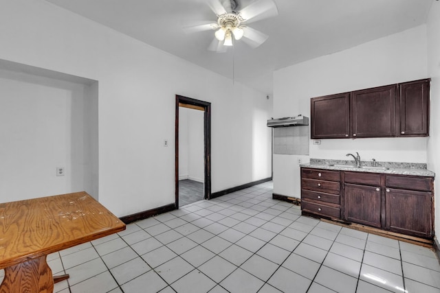 3031 S Central Park Ave, Chicago, IL 60623 - kitchen with light countertops, a ceiling fan, dark brown cabinets, light tile patterned flooring, and under cabinet range hood
