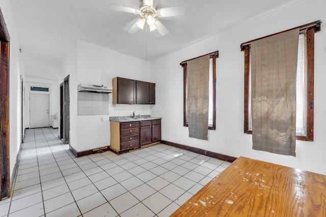 3031 S Central Park Ave, Chicago, IL 60623 - kitchen with light tile patterned flooring, a ceiling fan, dark brown cabinets, light countertops, and under cabinet range hood
