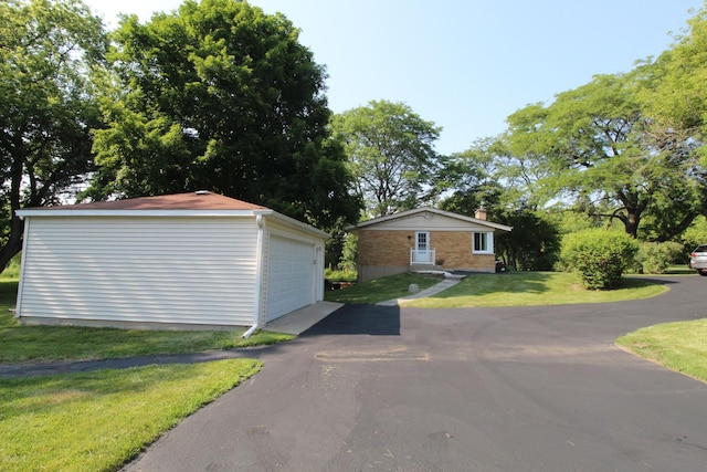 1906 Green Bay Rd, Zion, IL 60099 - view of side of property featuring an outdoor structure, a garage, a chimney, a lawn, and brick siding
