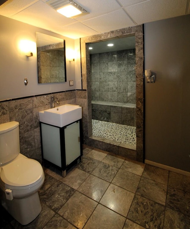 1906 Green Bay Rd, Zion, IL 60099 - bathroom featuring walk in shower, vanity, tile walls, and wainscoting