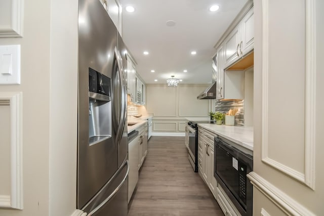111 E Chestnut St Unit 4400J, Chicago, IL 60611 - kitchen with stainless steel appliances, light countertops, wall chimney exhaust hood, recessed lighting, and wood finished floors