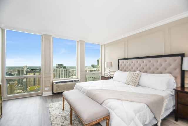 111 E Chestnut St Unit 4400J, Chicago, IL 60611 - bedroom featuring a decorative wall, wood finished floors, a city view, and a wall mounted AC