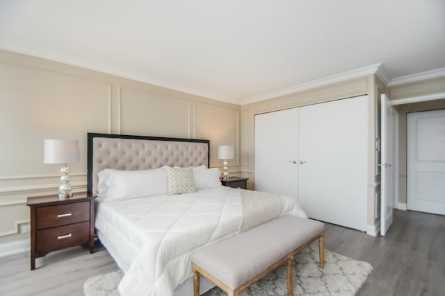 111 E Chestnut St Unit 4400J, Chicago, IL 60611 - bedroom featuring a decorative wall, ornamental molding, a closet, and light wood-style flooring