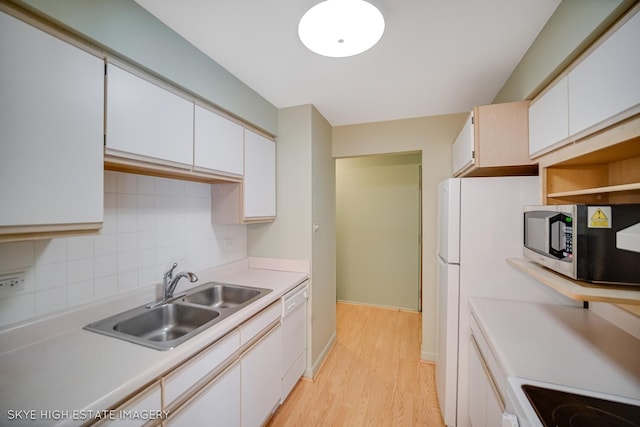 9716 S Karlov Ave S Unit 307, Oak Lawn, IL 60453 - kitchen with stainless steel microwave, white dishwasher, light wood-style flooring, light countertops, and tasteful backsplash