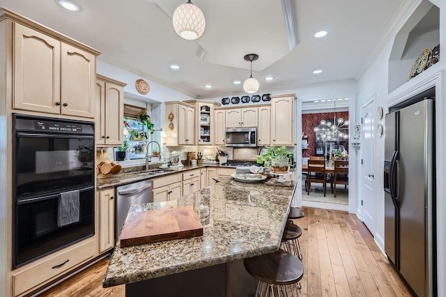 12740 Hawks Bill Ln, Plainfield, IL 60585 - kitchen featuring appliances with stainless steel finishes, a kitchen bar, dark stone counters, ornamental molding, and recessed lighting