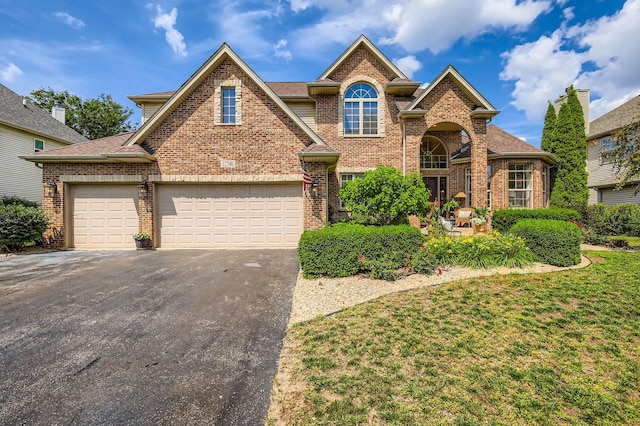 12740 Hawks Bill Ln, Plainfield, IL 60585 - traditional-style house with asphalt driveway, brick siding, and a front yard