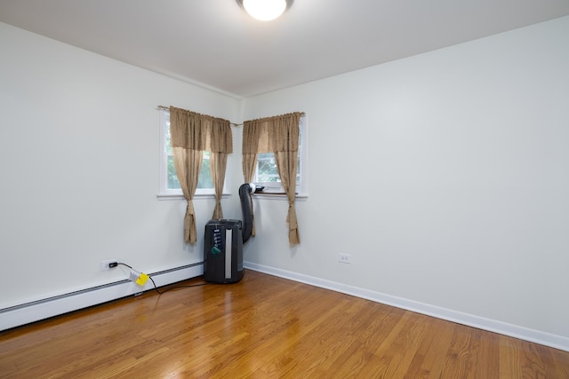 5457 W Edmunds St Unit 1A, Chicago, IL 60630 - empty room featuring a baseboard radiator and wood finished floors