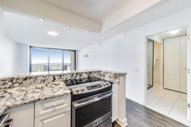 3660 N Lake Shore Dr Unit 3304, Chicago, IL 60613 - kitchen with electric range, white cabinetry, light stone counters, and recessed lighting