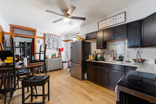 5121 W Henderson Ave, Chicago, IL 60641 - kitchen featuring radiator heating unit, stainless steel appliances, a ceiling fan, decorative backsplash, and light countertops