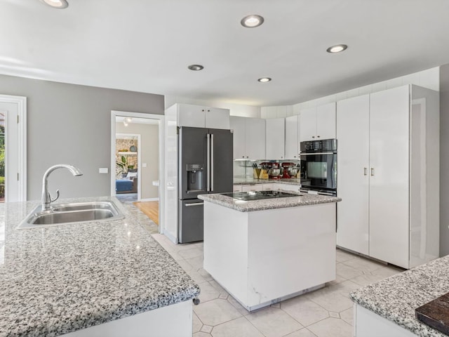 922 S School St, Mount Prospect, IL 60056 - kitchen with black appliances, a kitchen island, healthy amount of natural light, recessed lighting, and light stone countertops