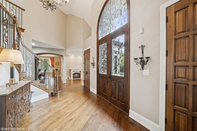 32W634 Oak Lawn Farm Rd, Wayne, IL 60184 - entryway with stairway, arched walkways, healthy amount of natural light, a warm lit fireplace, and high vaulted ceiling