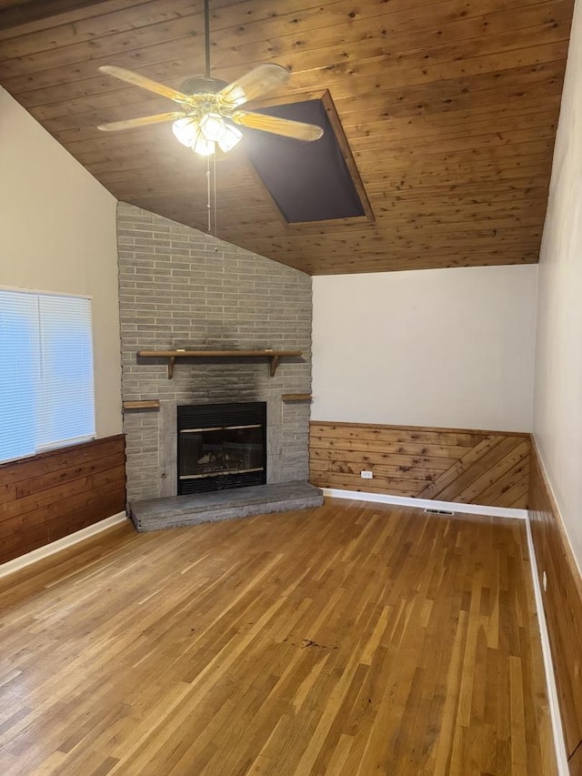 5125 W 101st St, Oak Lawn, IL 60453 - unfurnished living room featuring vaulted ceiling, wood finished floors, a ceiling fan, a fireplace, and wood walls