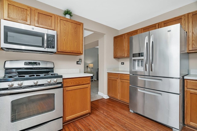 26226 W Tallgrass Trl, Channahon, IL 60410 - kitchen with appliances with stainless steel finishes, wood finished floors, light countertops, and brown cabinetry