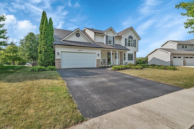 26226 W Tallgrass Trl, Channahon, IL 60410 - traditional-style home featuring a porch, asphalt driveway, a front lawn, and a garage