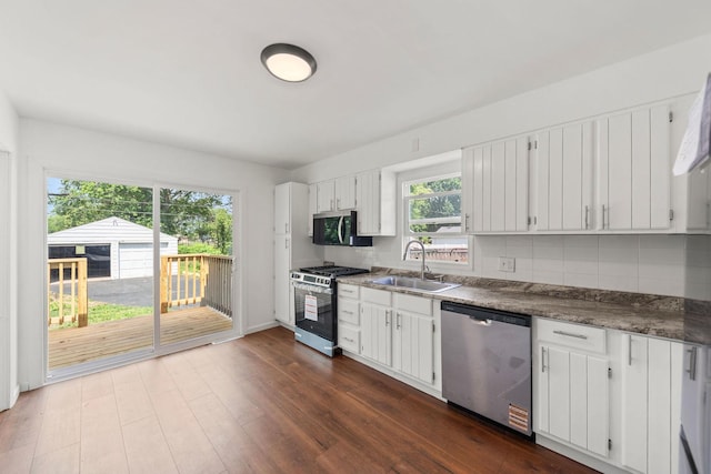 1063 S 8th Ave, Kankakee, IL 60901 - kitchen featuring stainless steel appliances, tasteful backsplash, dark wood-type flooring, and white cabinets